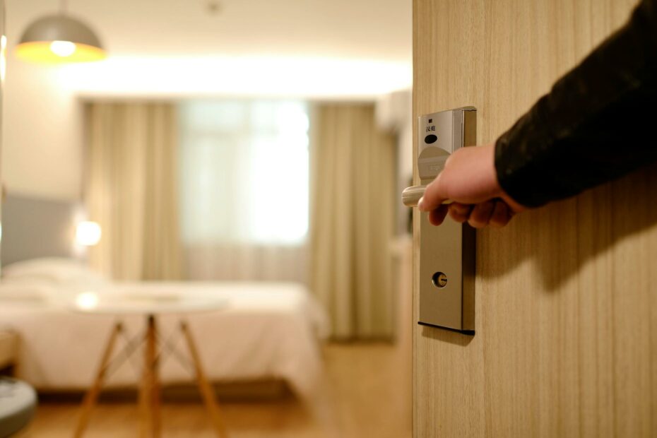 person holding on door lever inside room