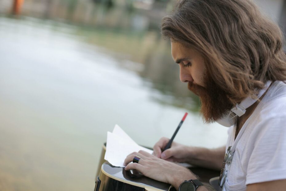 man in white shirt writing on a paper