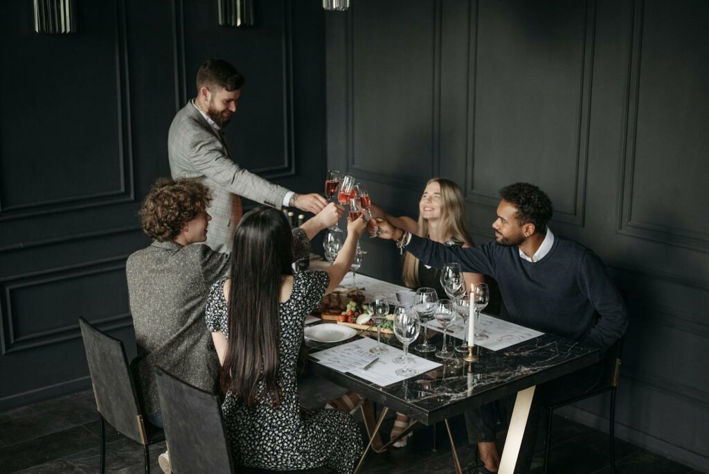 A sophisticated group enjoying a toast with wine at a stylish dinner setting, celebrating togetherness.
