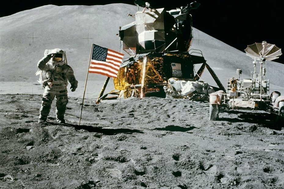 Astronaut on the moon near lunar module and American flag during historic landing.