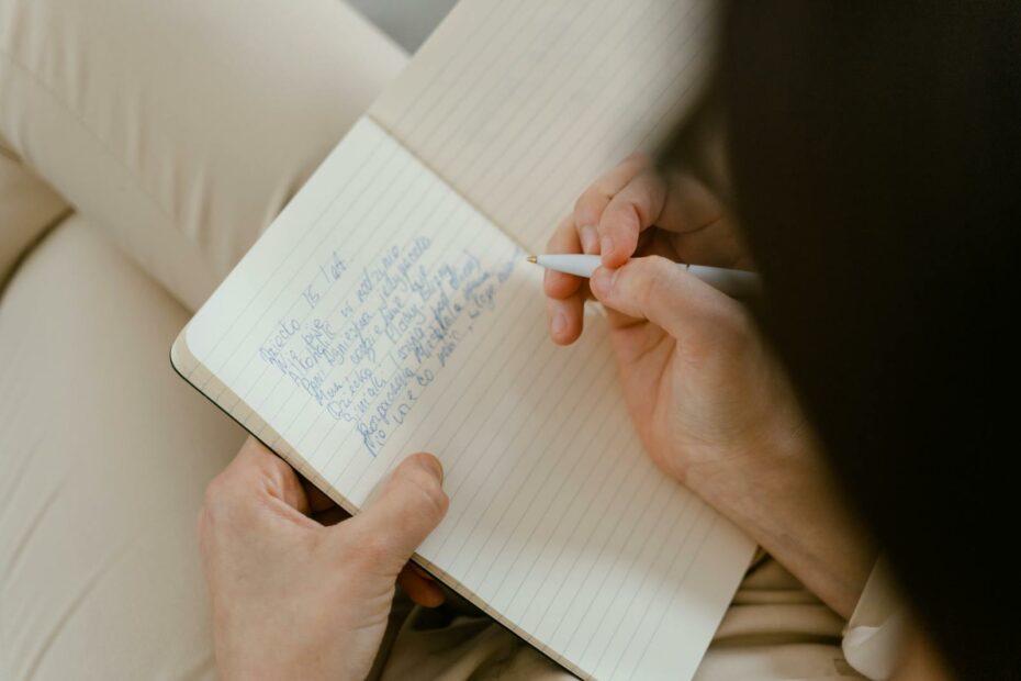 A person writes ideas in a notebook. Perfect for creativity and planning themes.
