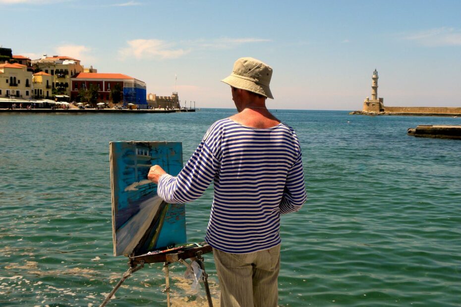 A painter capturing the scenic view of Chania lighthouse by the sea, Greece.