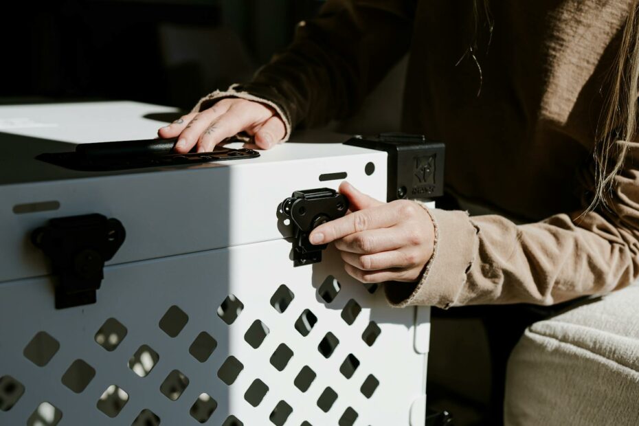 Hands securing a durable white dog crate, emphasizing pet safety and home lifestyle.