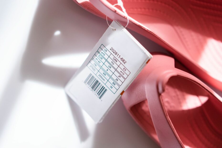 Detailed shot of pink sandals showing size tag and barcode for retail display.